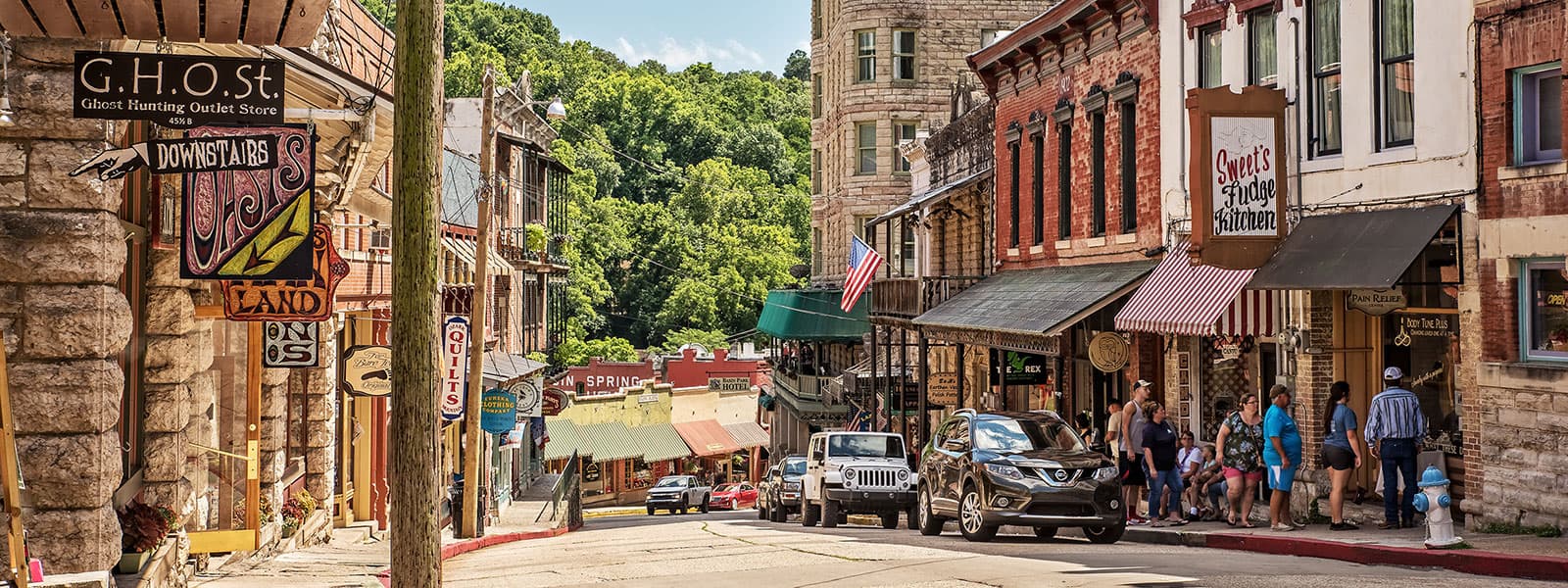 Victorian storefronts and shop signs along a street in downtown Eureka Springs