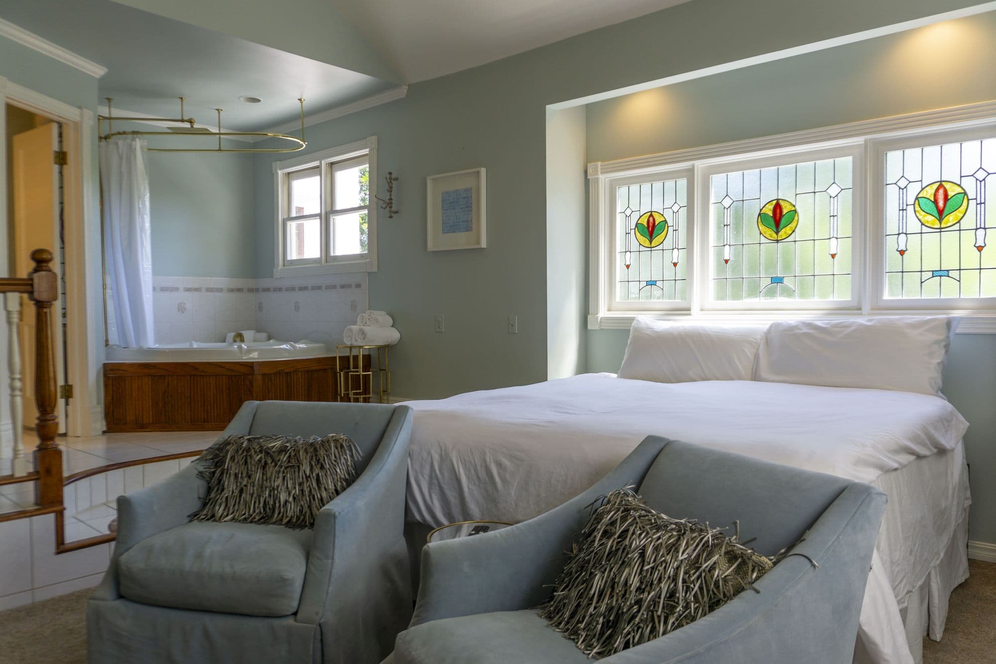 Hemingway Suite with a king bed beneath stained glass windows