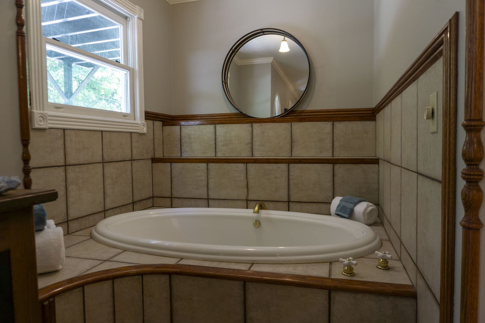 Tiled Jacuzzi beneath a round mirror in the Twain Suite