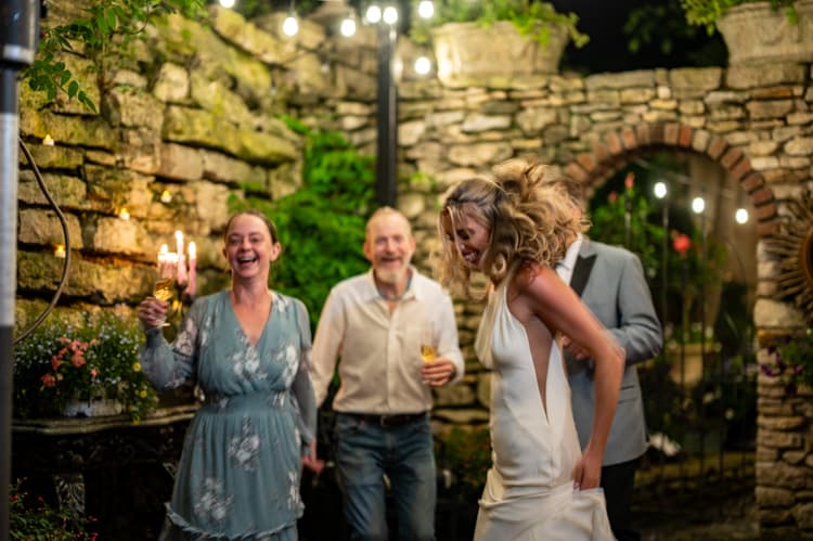 Guests laughing together in the garden courtyard at night